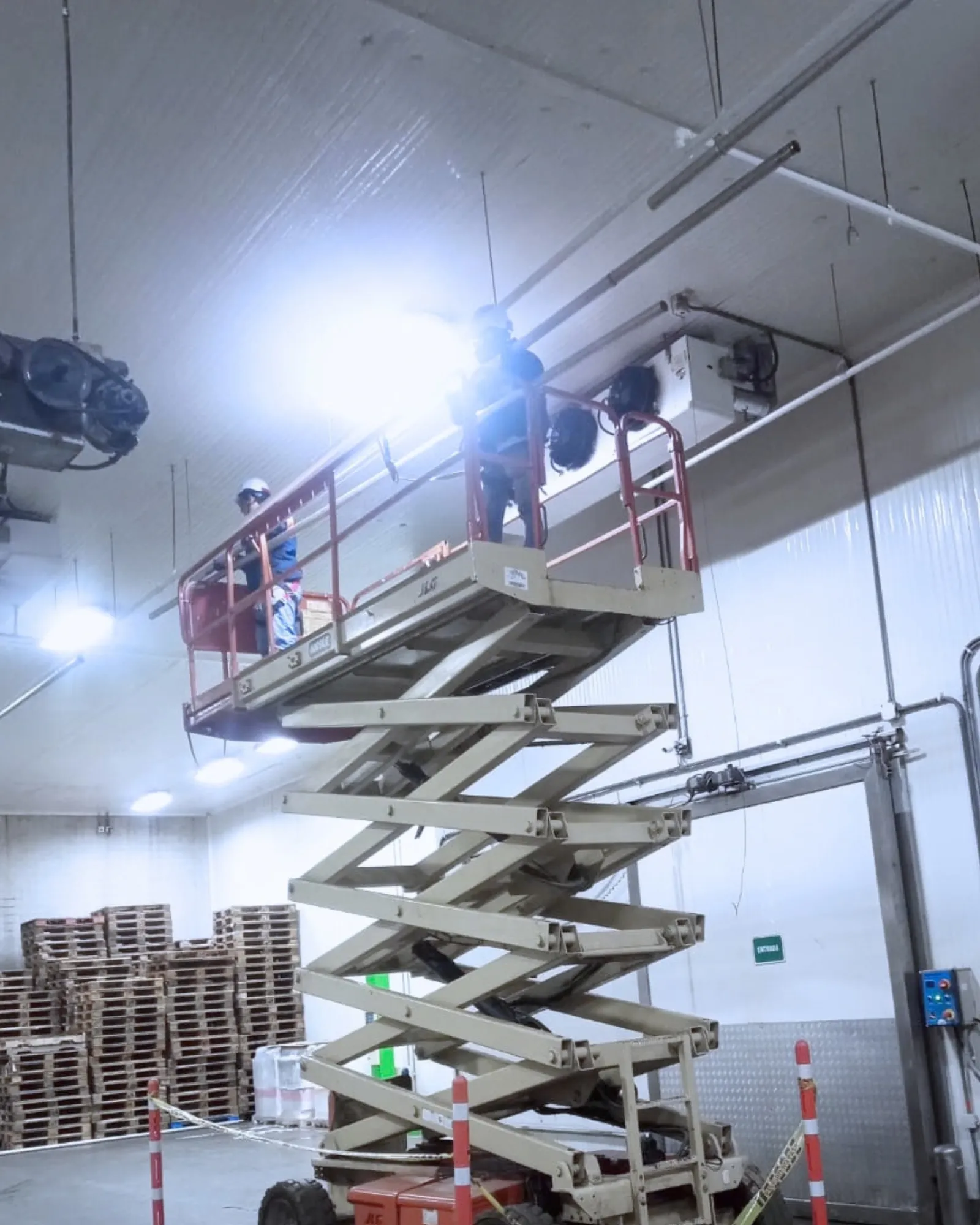 Trabajo de mantenimiento con plataforma elevadora en una instalación industrial.